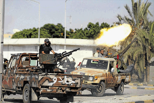 Libyan rebels fire at Muammar Gaddafi's Bab al-Azizya fortified compound in Tripoli yesterday Picture: ZOHRA BENSEMRA/REUTERS