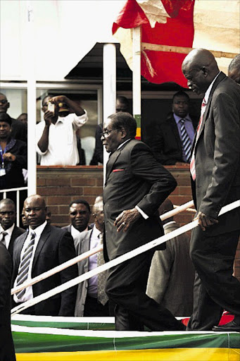 Zimbabwe's President Robert Mugabe, 90, falls down a staircase after addressing supporters at Harare International Airport yesterday. He was quickly helped up by aides and escorted to his limousine. Some photographers said security personnel forced them to delete their pictures of the fall.