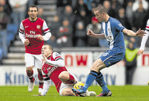 TOUGH NUT: David Jones, right, of Wigan Athletic competes with Jack Wilshere of Arsenal during their Premier League match yesterday