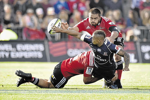 LOADED: Lions' flyhalf Elton Jantjies is tackled by the Crusaders' Nepo Laulala, top, and Jordan Taufua, left, during the match in Christchurch on Saturday