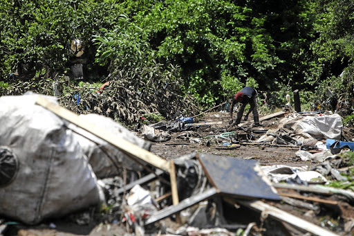 A resident searches for personal belongings at Mushroom Compound.