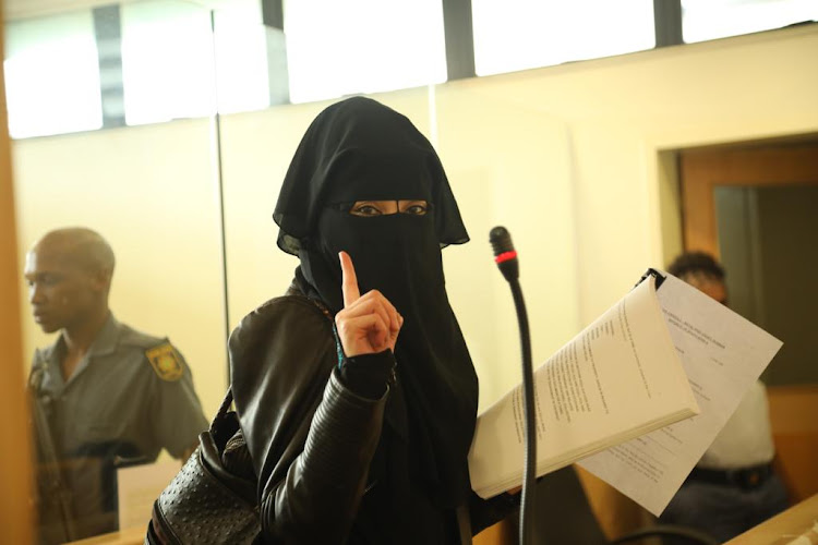 Fatima Patel, the common law wife of Aslam Del Vecchio raises a single index finger. The gesture which is said to signify the "oneness of God" in Islam however has been adopted by jihadists within the Islamic State. She appeared in the Verulam magistrate's court on terror-related charges.