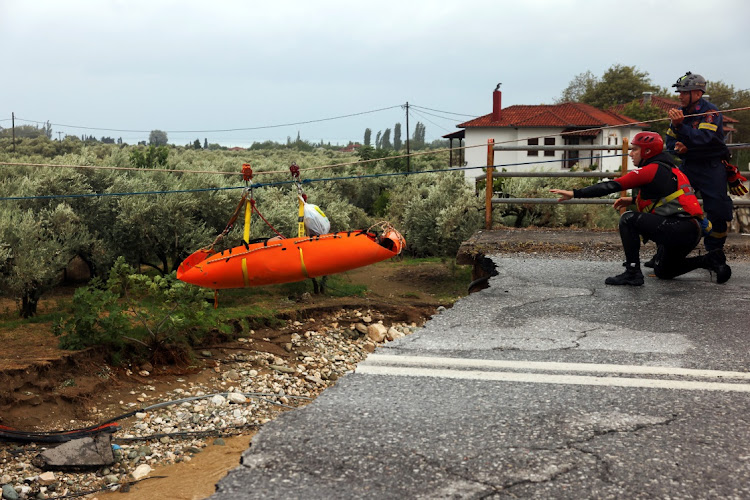 Rescuers transfer a chronic kidney disease patient over a collapsed bridge in a flooded area, as storm Daniel hits central Greece, in the village of Kala Nera, near Volos, Greece, September 6, 2023.