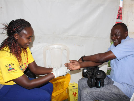 KTN Cameraman JohnsonLangat is tested for HIV by Kenyatta National Hospital counsellor Daisy Chemutai at the Nyayo National Stadium, Nairobi, on December 1 last year during World Aids Day.