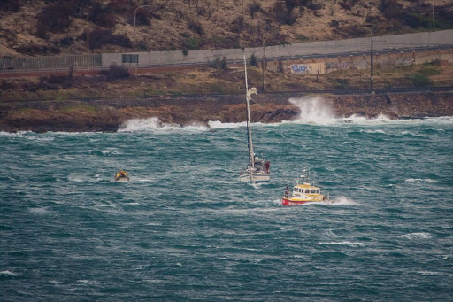 Members of the National Sea Rescue Institute based at Simon’s Town in the Western Cape assist one of the four yachts battling against 50 knot winds.