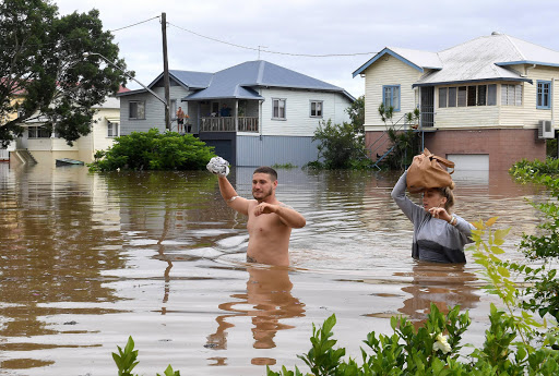 Local residents wade through floodwaters near their homes in the northern New South Wales town of Lismore, Australia, after heavy rains associated with Cyclone Debbie swelled rivers to record heights across the region. AAP/Dave Hunt/via REUTERS