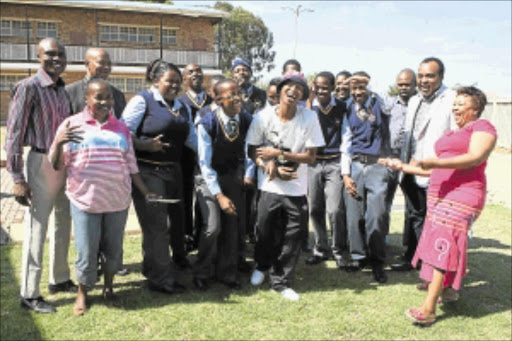 GIVING BACK: Mandla Mofokeng,middle, donated school uniform to poor pupils at Meadowlands Secondary School in Soweto yesterday. PHOTO: MOHAU MOFOKENG