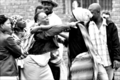 ANGRY WOMAN: A squabble broke out outside court after Letty Shikundu, centre, accused the local civic association of being behind the denial of bail for her husband Freddie. Pic. Elmon Tshikhudo. 07/10/08. © Sowetan.