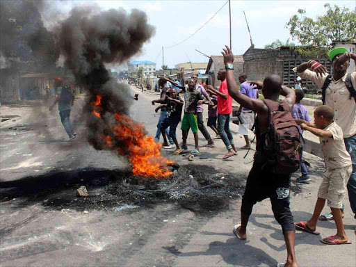 Demonstrators burn tyres to set up barricades during a protest in DRC's capital Kinshasa, over proposed changes to an election law that could delay a vote due in 2016 and allow President Joseph Kabila to stay in power, January 20, 2015. /REUTERS