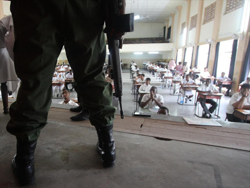 Armed officer keeps vigil as KCSE candidates do a paper. file