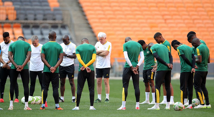 Bafana Bafana players and coach Hugo Broos pray before their training session at FNB Stadium on Monday.