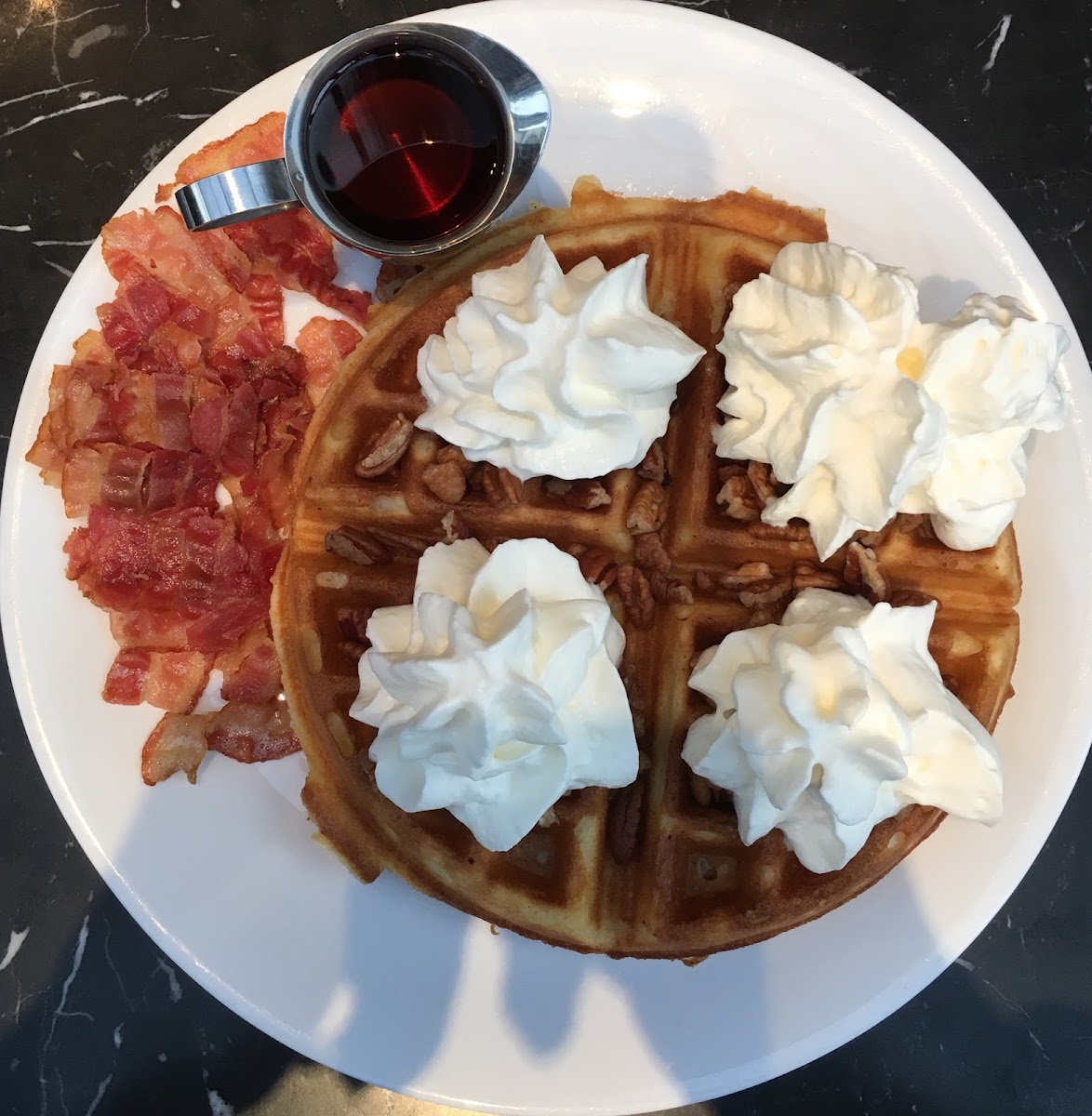 Pecan Waffle with Maple Syrup and a side of bacon.
