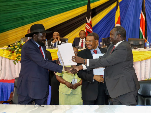 South Sudan President Salva Kiir and rebel leader Riek Machar during the signing of the SPLM Reunification Agreement, that was overseen by Tanzania's President Jakaya Kikwete (centre) in Arusha, Tanzania, January 22, 2015. Photo/PSCU