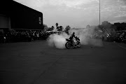 A biker creates smoke after the hearse carrying Nick Durandt departs.