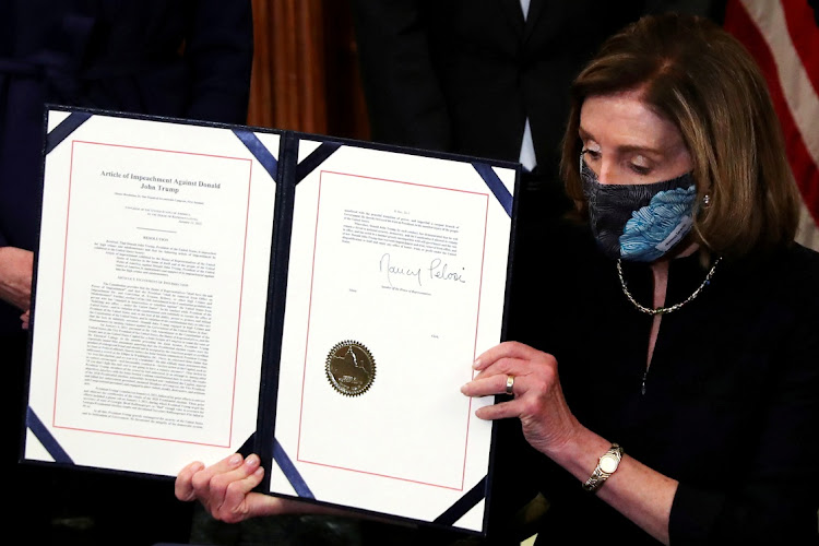 U.S. House Speaker Nancy Pelosi (D-CA) shows the article of impeachment against U.S. President Donald Trump after signing it in an engrossment ceremony, at the U.S. Capitol in Washington on January 13, 2021.