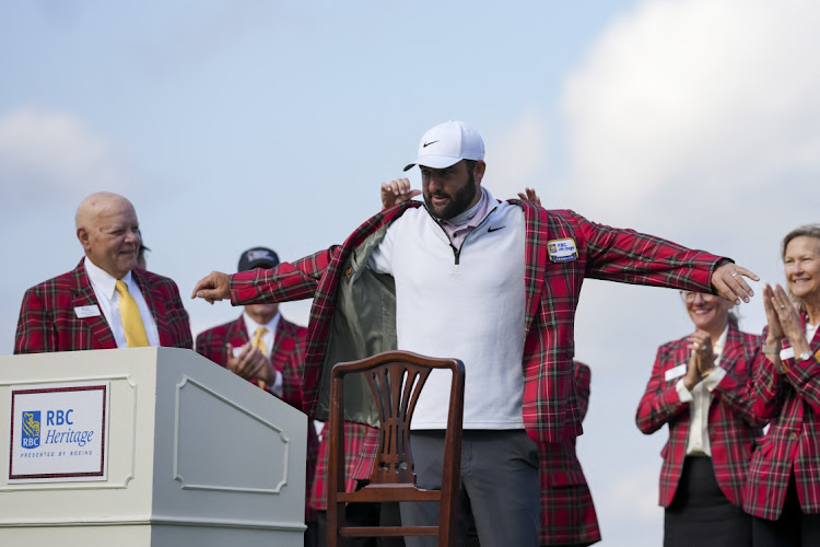 Scottie Scheffler puts on his plaid jacket after winning the RBC Heritage tournament at Hilton Head, South Carolina on April 22, 2024.