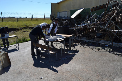 Students use a destroyed classroom to do their art.