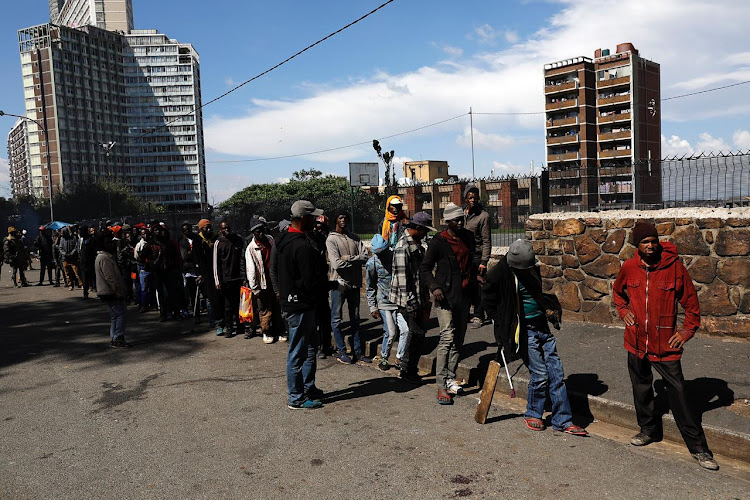 People queuing for food parcels in downtown Johannesburg. Politicians' credibility is so damaged that their pleas to the poor to stop looting were 'but a cruel joke', says Anglican archbishop Thabo Makgoba.