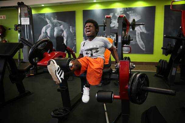 Caleb grimaces as he demonstrates how he works his legs, during an intense training session at Trinergy Health and Fitness Centre, close to the orphanage where he lives. The 19 year old was born with a sickle-cell disease (SCD) in The Democratic Republic of Congo (DRC) and now lives at Kids Haven, an orphanage east of Johannesburg. His trainer , Ryan Manthe of Trinergy Health and Fitness Centre, was inspired to help him after seeing him get up on stage with other bodybuilders at a competition in Kempton Park.