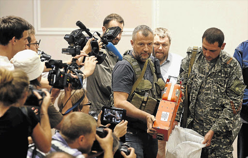 KEY TO THE PUZZLE: Pro-Russian separatists bag up one of the black boxes belonging to Malaysia Airlines flight MH17, before handing it over to Malaysian representatives in Donetsk, Ukraine