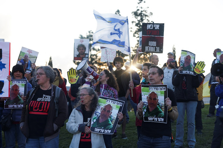 People hold posters as Israelis attend a protest calling for a deal and the release of Israeli hostages held in Gaza as Israeli Prime Minister Benjamin Netanyahu holds a cabinet meeting, amid the ongoing conflict between Israel and the Palestinian Islamist group Hamas in Gaza, outside Prime Minister's office in Jerusalem, April 9, 2024.