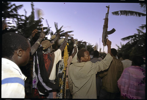 A man from the Ugandan army brandishes a rifle during a circumcision ceremony. The writer says firing randomly at parties and funerals is now a fully entrenched culture in South Africa. /CORBIS SABA/Corbis via Getty Images / Louise Gubb