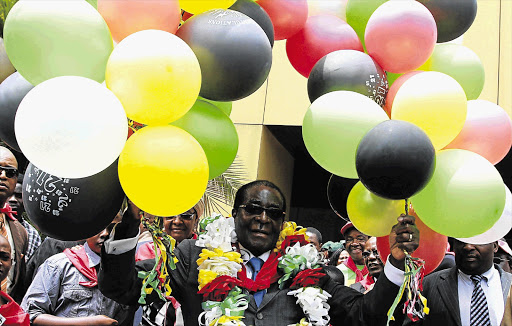 President Robert Mugabe, centre, holds onto 87 balloons as he celebrates his birthday at a rally organised by his Zanu-PF party in Harare last year. Mugabe turns 88 on Tuesday