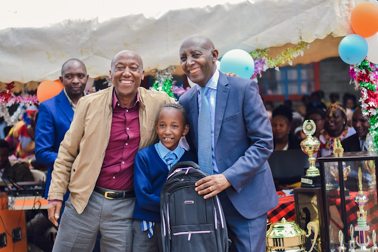 Limuru MP John Kiragu awards a pupil for good performance at Limuru town school during the school's prize giving day.
