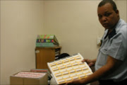 NO AIR: Malose Mashiane of Sunnyside police with boxes containing sealed airtime vouchers from various networks. Pic. Kopano Tlape. © Sowetan.