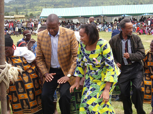 Nyandaru governor aspirant Moses Kiarie and woman representative Wanjiku Muhia join Mau Mau veterans in a dance during celebrations to mark Mashujaa Day in Kipipiri Stadium on Thursday /NDICHU WAINAINA