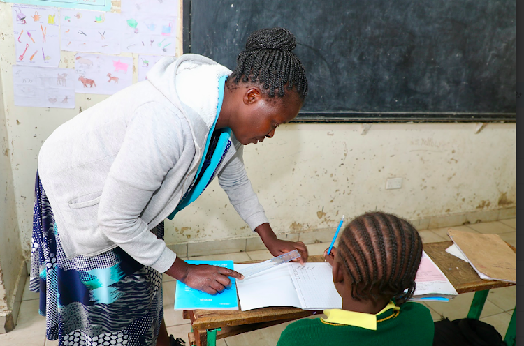 A teacher takes a Grade 4 pupil through a lesson at Oloolua Primary School in Kajiado county.