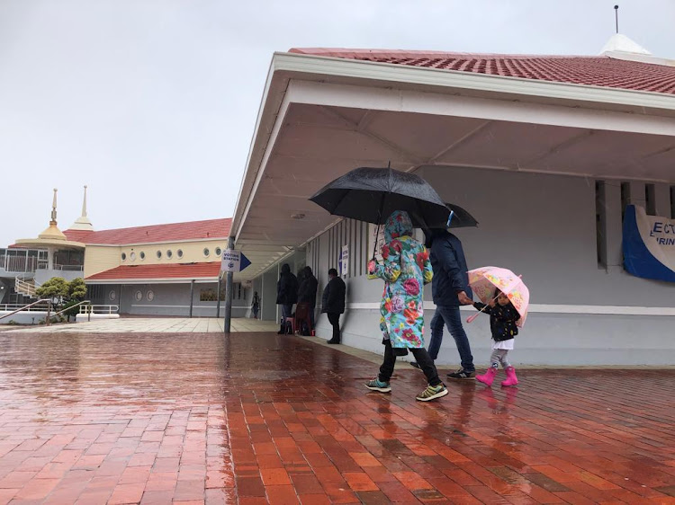 Voters faced pouring rain while they waited at the Muizenberg Pavilion polling station in Cape Town.