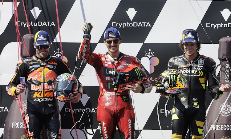 Francesco Bagnaia celebrates winning the race with second placed Brad Binder, left, and third placed Marco Bezzecchi. Picture: REUTERS