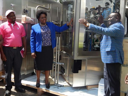 CEO of the New KCC Nixon Sigei (R) with Bomet Governor Joyce Laboso receiving modern dairy processing equipment at Sotik New KCC factory on July 2nd