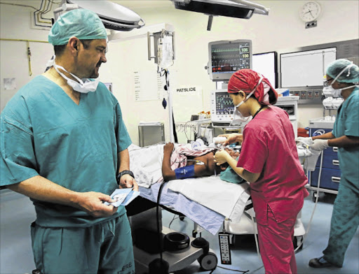 EXPERT TEAM: Dr Gary Kroukamp, from the Western Cape’s Tygerberg Hospital, and his team during the successful cochlear implant operation on 12-year-old Sigcobile Jako, which was performed at Frere Hospital Picture: MICHAEL PINYANA