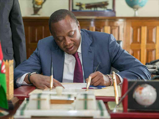 A file photo of President Uhuru Kenyatta signing a bill into law