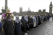 STANDING TALL: Women hold hands in silence on Westminster Bridge, London, in remembrance of the victims of last week's attack.