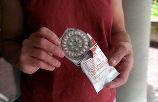 A woman holds prescription contraceptives. File photo.