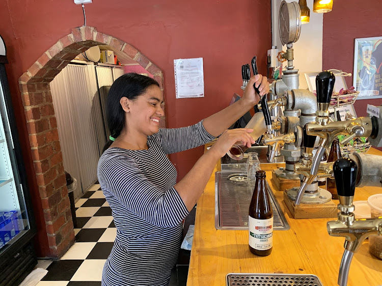 Waitress Kaylin Du Plessis taps a beer crafted at Tsitsikamma Village Inn’s microbrewery