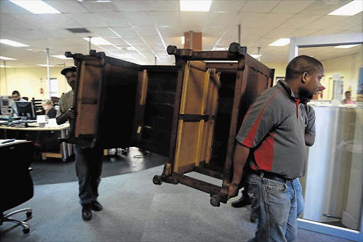 DONALD’S PERCH: Furniture removers carry the melamine desk that belonged to former Daily Dispatch editor Donald Woods. Woods, an anti-apartheid editor, became a household name after befriending black consciousness leader Steve Biko. The desk left the Caxton Street building yesterday Picture: ALAN EASON