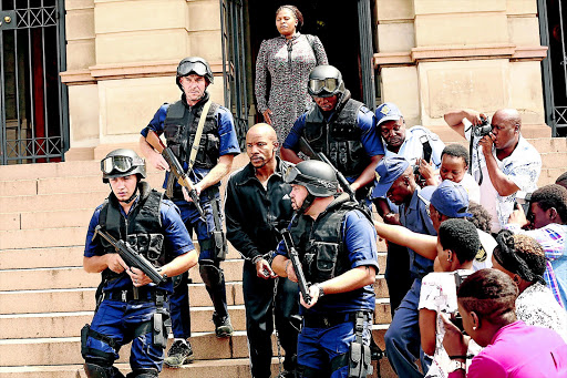 Mduduzi Mabaso, handcuffed, plays the role of the late heist kingpin Collen Chauke in the film 'State Enemy no.1'.