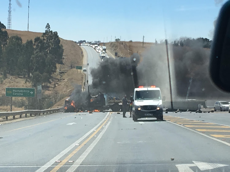 A truck burning on the N4 on Friday after angry community members set it alight due to the release of two white men accused of assaulting a black man.