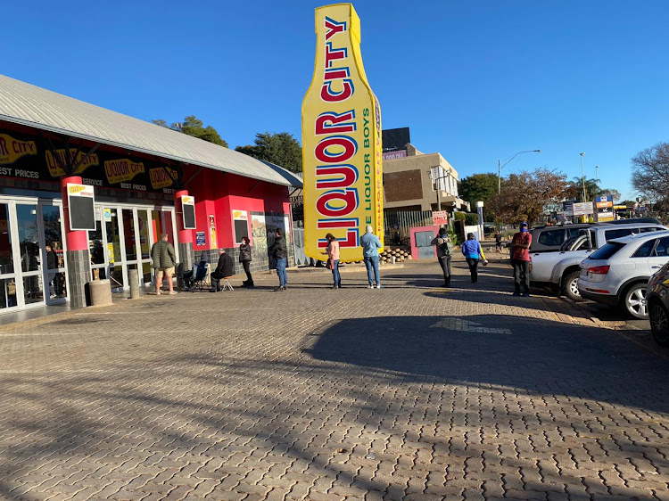 Ten people and counting standing in a queue outside the Liquor City in Northcliff, with masks on and clear social distancing measures in sight - and camp chairs.