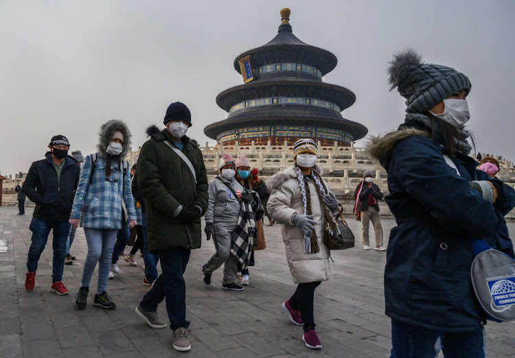 Visitors wear protective masks to guard against coronavirus as they tour the grounds of the Temple of Heaven on January 27 2020 in Beijing, China.