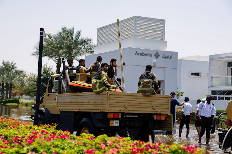 Members of a fire and rescue team travel on a truck on flooded roads in a residential community in Dubai, United Arab Emirates. Picture: Reuters/Rula Rouhana
