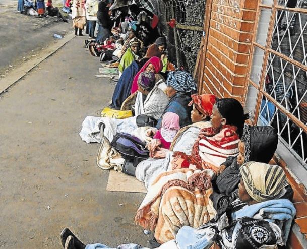 Social grant beneficiaries, mostly women, wait outside a Sassa office. File photo.