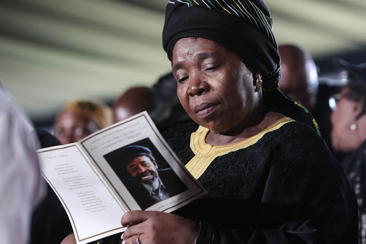 Nkosazana Dlamini Zuma reads over the program at the funeral service.