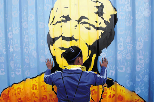 Children added their handprints to the artwork on a container that has been transformed into a library for underprivileged children at the V&A Waterfront in Cape Town. At exactly 8am almost 13 million children sang 'Happy Birthday' to Madiba