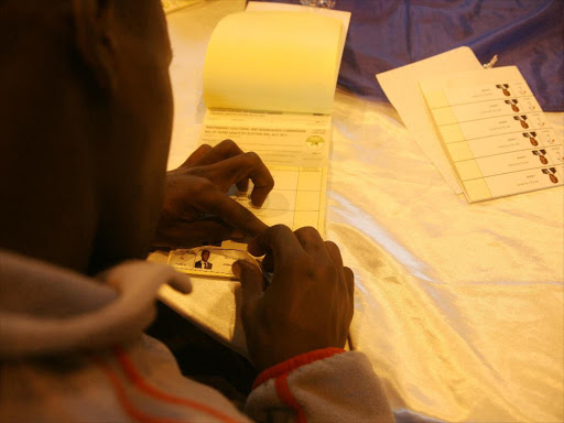 A file photo of IEBC staff stick strips on ballot papers .Photo/HEZRON NJOROGE