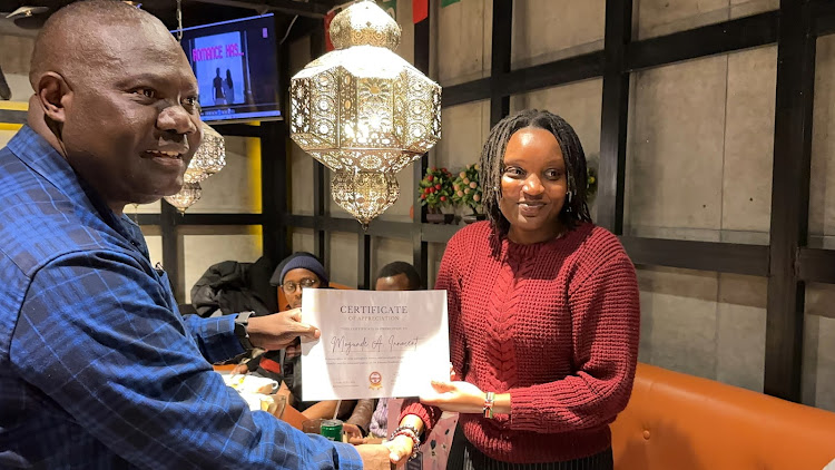 Education Attaché Innocent Mogunde receives a certificate of appreciation from KENSAB president Yvonne Kendi in Beijing on February 25, 2024